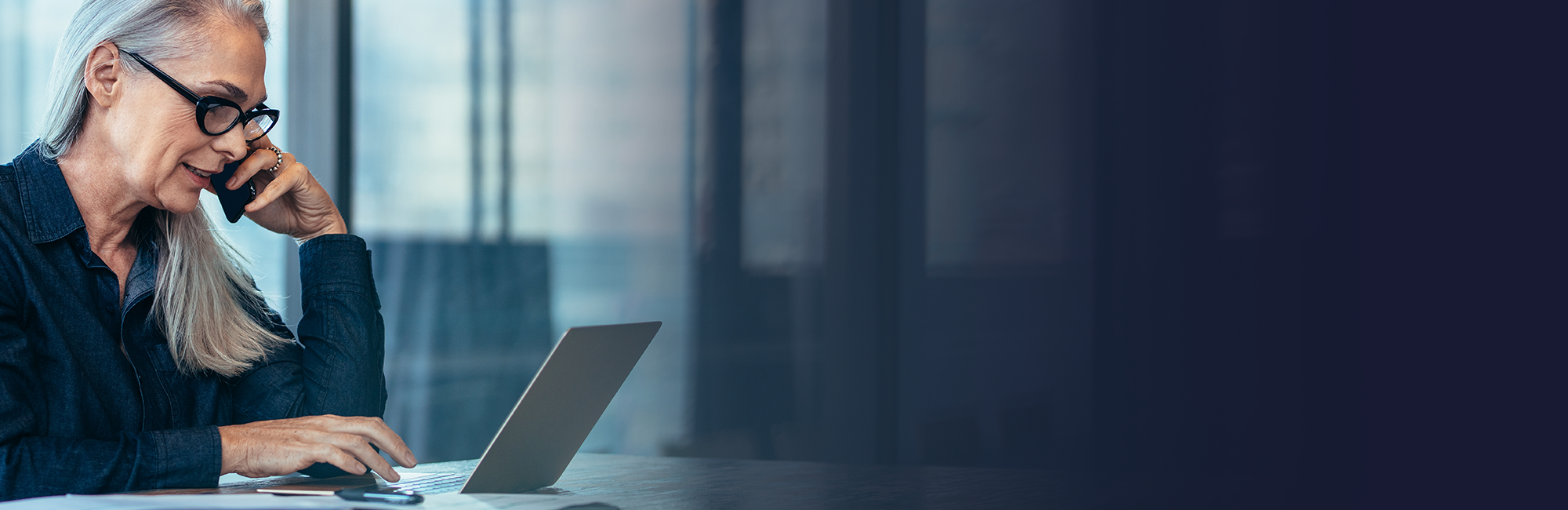 a person on their phone using a laptop