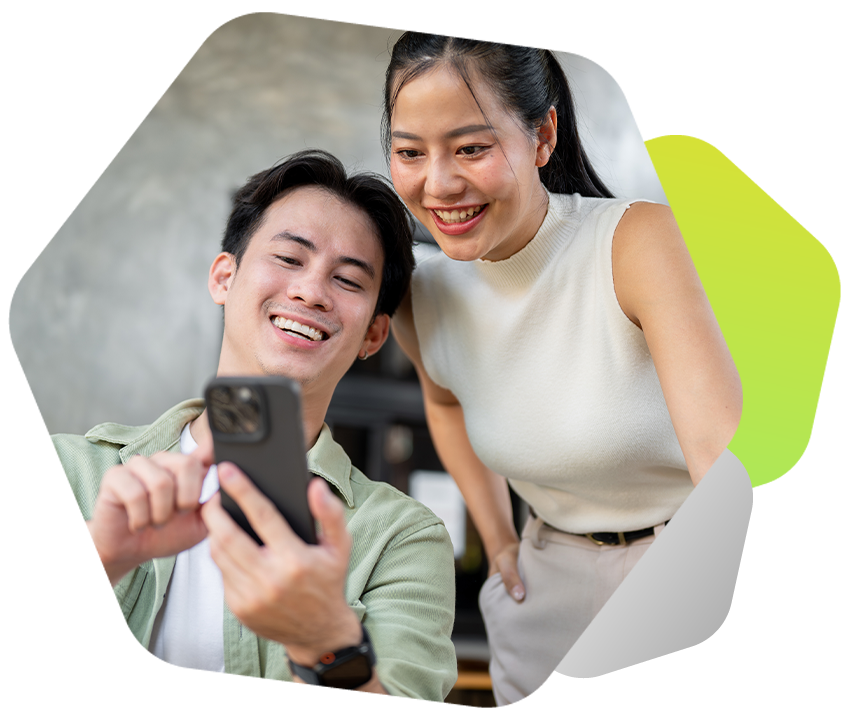 2 people smiling in an office looking at a mobile phone