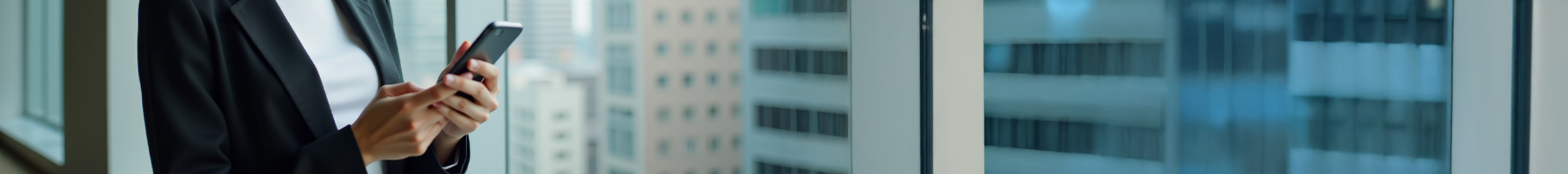 person holding a mobile phone next to a window