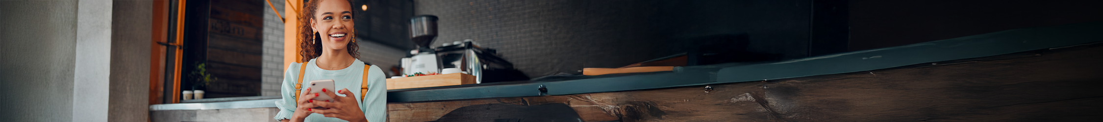 person sat at a cafe using their mobile phone