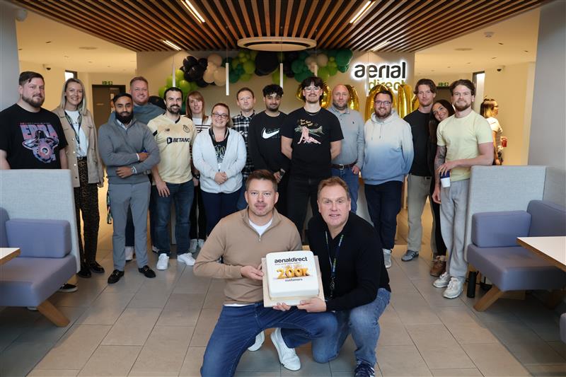 aerial direct staff holding a 200k connections cake